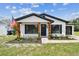Inviting home with black trim, an American flag, and fresh landscaping, offering great curb appeal at 102 Shore E Dr, Oldsmar, FL 34677