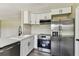 Modern kitchen featuring stainless steel appliances, white cabinets and gray countertops at 102 Shore E Dr, Oldsmar, FL 34677