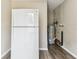 View of the pantry area with a white refrigerator, water heater, and vinyl flooring at 102 Shore E Dr, Oldsmar, FL 34677