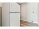 Spacious pantry area with white refrigerator, light gray concrete walls, and vinyl floors at 102 Shore E Dr, Oldsmar, FL 34677