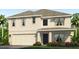 Two-story house with light beige siding, dark gray door, and landscaping at 11121 40Th E Ave, Palmetto, FL 34221