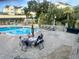 Community swimming pool with people enjoying the sunshine around a table at 1235 S Highland Ave # 2-206, Clearwater, FL 33756