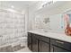 Clean bathroom with dark vanity, shower, and white toilet at 30399 Marquette Ave, Wesley Chapel, FL 33545