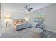 Bright bedroom with tufted headboard bed, ottoman, and chair at 30399 Marquette Ave, Wesley Chapel, FL 33545