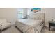 Bedroom with beige upholstered bed and fluffy chair at 30399 Marquette Ave, Wesley Chapel, FL 33545