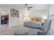 Bedroom with tufted bed, chair, ottoman, and walk-in closet at 30399 Marquette Ave, Wesley Chapel, FL 33545