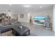 Open living area with gray reclining sofas, large TV, and Christmas tree at 30399 Marquette Ave, Wesley Chapel, FL 33545