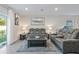 Spacious living room featuring gray reclining sofas, a coffee table, and wood-look floors at 30399 Marquette Ave, Wesley Chapel, FL 33545