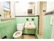 Mint green tiled bathroom with toilet, sink, and shower at 333 Bay Plz, Treasure Island, FL 33706