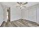 Bedroom with wood-look floors, ceiling fan and door to hallway at 3870 Island Way, St Petersburg, FL 33705