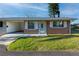 One-story home with brick facade, white shutters, and a covered carport at 4987 Jonquil N Pl, Pinellas Park, FL 33782