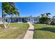 Landscaped backyard showcasing a covered patio and brick walkway at 568 Johns Pass Ave, Madeira Beach, FL 33708