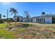 House exterior showcasing a ranch style home with a spacious lawn and palm trees at 568 Johns Pass Ave, Madeira Beach, FL 33708