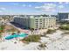 Aerial view of condo building, pool, and beach access at 12000 Gulf Blvd # 212-N, Treasure Island, FL 33706