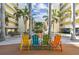 Colorful chairs and a giant Jenga game in a tropical courtyard at 12000 Gulf Blvd # 212-N, Treasure Island, FL 33706