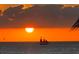 Orange sunset over ocean with sailboat in the foreground at 12000 Gulf Blvd # 212-N, Treasure Island, FL 33706