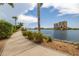 Curved waterfront pathway with lush landscaping and water views at 140 Riviera Dunes Way # 1001, Palmetto, FL 34221