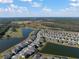 Community aerial view of homes and picturesque pond against a backdrop of lush green landscapes at 14426 Woodland Spur Dr, Lithia, FL 33547