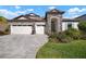 Two-story home with stone accents, three-car garage, and landscaped yard at 14426 Woodland Spur Dr, Lithia, FL 33547