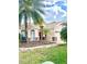 Tan two-story house with red door, palm trees, and stone accents at 18007 Malakai Isle Dr, Tampa, FL 33647