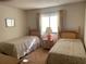 Bedroom with two twin beds, a nightstand, and curtains on the window at 2165 Corbin Pl # A, Palm Harbor, FL 34683