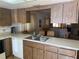 Kitchen with wood cabinets, double sink, and a pass-through window to the dining area at 2165 Corbin Pl # A, Palm Harbor, FL 34683