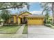 Beautiful yellow house with a two-car garage and landscaped lawn at 3022 Beaver Pond Trl, Valrico, FL 33596