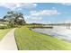 Peaceful waterfront walkway with lush grass at 3022 Beaver Pond Trl, Valrico, FL 33596