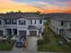 Two-story townhome with gray siding, two-car garage, and nicely landscaped yard at 36522 Well Hill Way, Zephyrhills, FL 33541