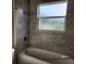 Bathroom showcasing a tub with tiled walls and a window for natural light at 413 Shannon Estates Ct, Plant City, FL 33563