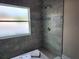 Modern tiled shower with mosaic accents and a frosted window for natural light at 413 Shannon Estates Ct, Plant City, FL 33563