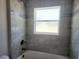 Bright bathroom features a tiled shower, a showerhead, and a window at 413 Shannon Estates Ct, Plant City, FL 33563