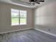 Bedroom with a large window, tray ceiling, and stylish gray flooring at 413 Shannon Estates Ct, Plant City, FL 33563