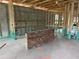 Interior under construction showcasing stud framing, cement block walls, and a brick accent wall at 413 Shannon Estates Ct, Plant City, FL 33563