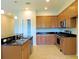 A modern kitchen with wooden cabinets, stainless steel appliances, a breakfast bar and granite countertops at 413 Shannon Estates Ct, Plant City, FL 33563