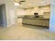 A spacious kitchen with tiled floors, white cabinets, granite countertops, and stainless steel appliances at 413 Shannon Estates Ct, Plant City, FL 33563