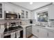 White kitchen with stainless steel appliances and a marble backsplash at 4304 Woodfield Ave, Holiday, FL 34691