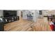 Open concept living space with hardwood floors, a modern kitchen, and a large TV at 4304 Woodfield Ave, Holiday, FL 34691