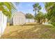 Backyard shed with white fence, palm trees, and grassy area at 897 Imperial Dr, Largo, FL 33771