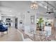 Open dining area with a glass-top table and white chairs, adjacent to kitchen at 107 17Th St, Belleair Beach, FL 33786