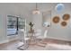 Modern dining area with a glass table, white chairs, and a chandelier at 107 17Th St, Belleair Beach, FL 33786