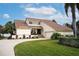 Two-story house with light-yellow walls, brown roof, and a landscaped lawn at 107 17Th St, Belleair Beach, FL 33786