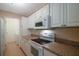 White kitchen with granite counters and appliances at 1400 Gandy N Blvd # 715, St Petersburg, FL 33702