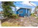 Side yard view of blue house, landscaping, and AC unit at 1409 Ne 49Th Ne Ave, St Petersburg, FL 33703