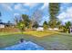 Expansive backyard with a paved patio, lush lawn, and landscaping at 1415 Yale Dr, Holiday, FL 34691