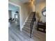 The foyer features light gray wood-look flooring, a staircase with a black metal railing, and a view into the dining area at 14160 82Nd Ter, Seminole, FL 33776