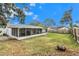 Large backyard with screened patio, grassy area, and wooden fence at 504 Highview S Cir, Brandon, FL 33510