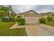 Tan one-story house with a two-car garage and manicured lawn at 529 Laguna Mill Dr, Ruskin, FL 33570