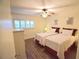 Cozy bedroom with two twin beds, ceiling fan, and ample natural light at 920 Virginia St # 204, Dunedin, FL 34698