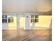 Exterior elevation of a home with covered walkway, front door, and windows with shutters at sunset at 920 Virginia St # 204, Dunedin, FL 34698